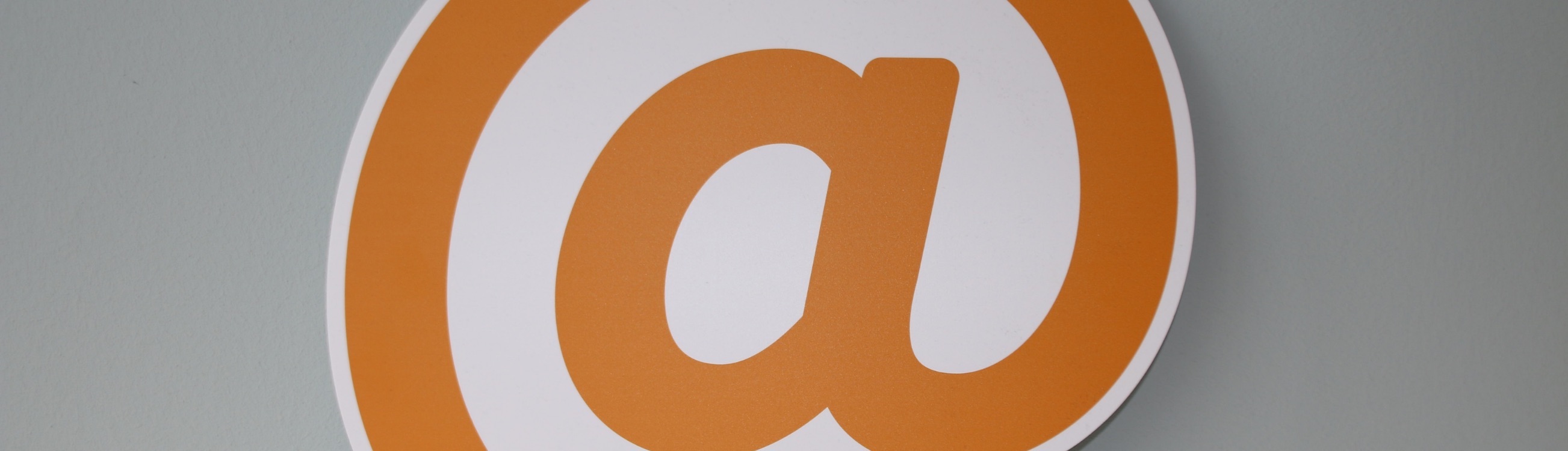 Une icône arobase en orange et blanc 